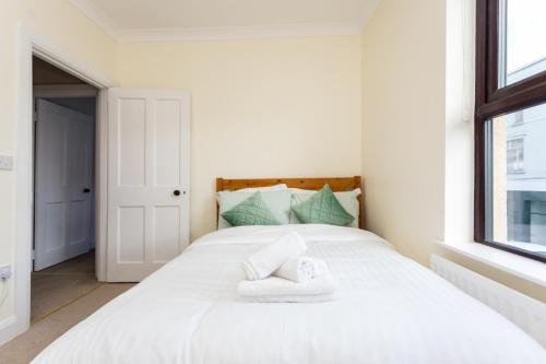 a bedroom with a white bed with towels on it at Cosy Home Swinford Town in Swinford