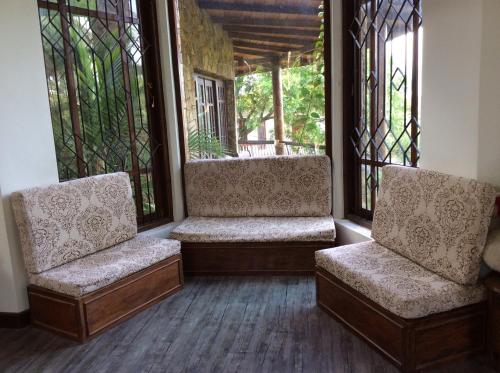two chairs sitting in a porch with windows at Mount Haven in Kandy