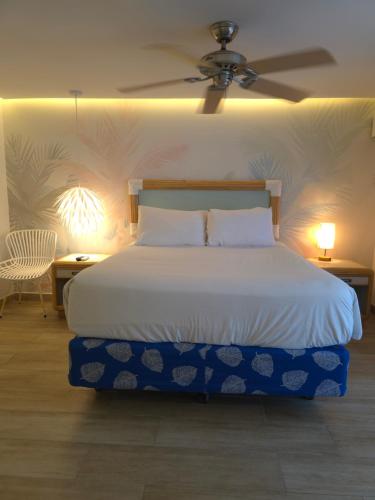 a bedroom with a white bed with a ceiling at Hotel Cocoplum Beach in San Andrés