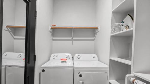 a small white laundry room with two white washes at Charming & Spacious Hideaway by Downtown Bryan in Bryan