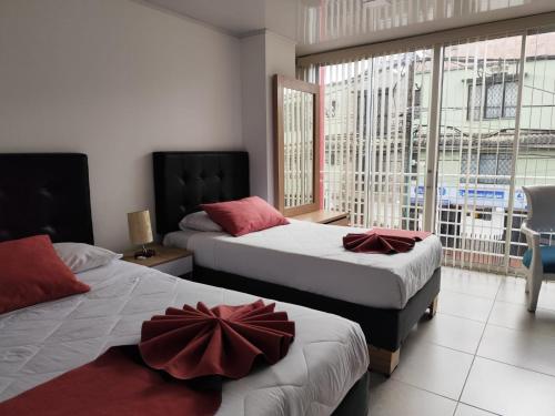 a bedroom with two beds and a large window at Hotel Monarka-Edificio in Popayan