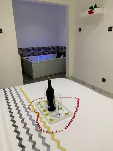 a bottle of wine sitting on a table in a room at Appart'hotel avec jacuzzi à Adjarra in Adjarra