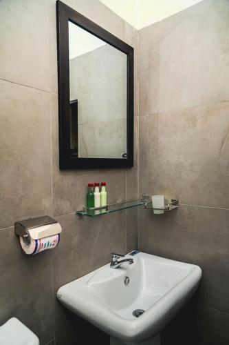 a bathroom with a sink and a mirror at Roshara The Airport Hub in Katunayake