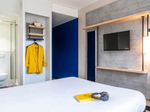 a bedroom with a bed with a yellow item on it at ibis budget Paris Porte de Montreuil in Montreuil
