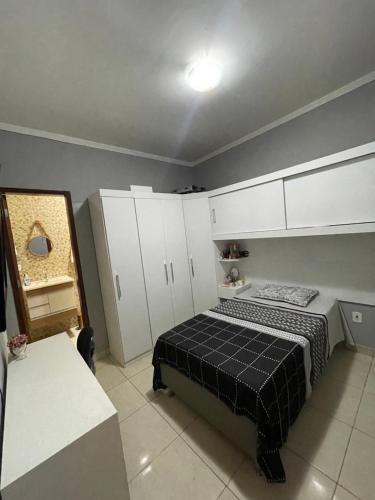 a bedroom with a bed and white cabinets at Quarto no centro da cidade! in Petrolina