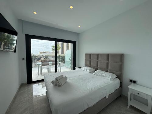 una camera da letto con un letto grande con una grande finestra di Sunset Waves I by Terreta Rentals a Benidorm