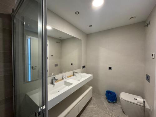 un bagno con lavandino, WC e specchio di Sunset Waves I by Terreta Rentals a Benidorm