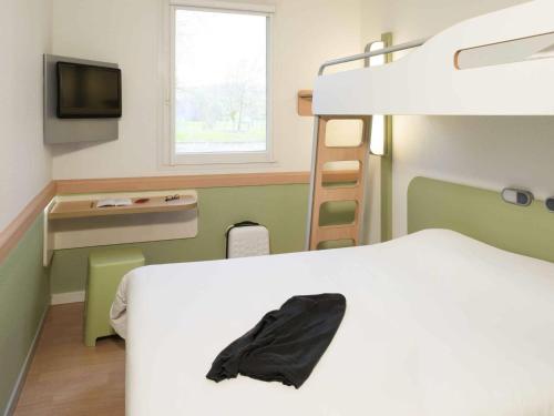 a bedroom with a bed and a bunk bed at ibis Budget Lons-le-Saunier in Lons-le-Saunier