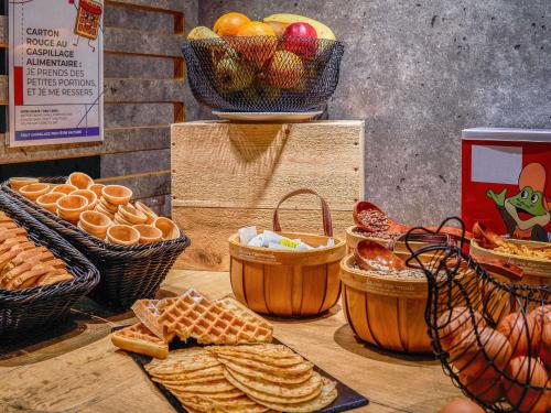 a table with baskets of bread and baskets of fruit at ibis budget Bordeaux Centre - Gare Saint Jean in Bordeaux