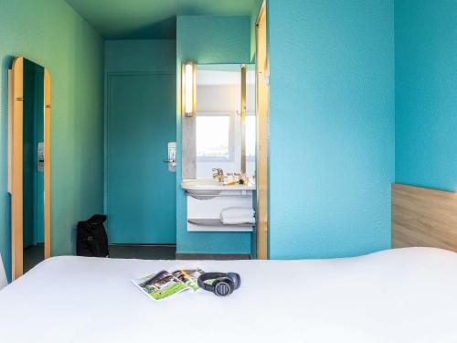 a bedroom with a bed and a sink and a mirror at ibis budget Orly Rungis in Rungis