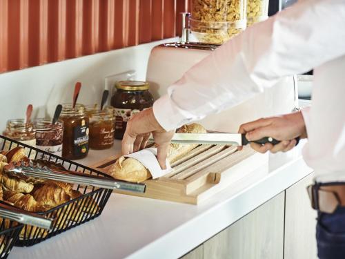 a chef preparing food on a shelf in a kitchen at ibis budget Issoire in Issoire