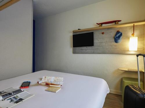 a room with a bed with a tv on the wall at Ibis Budget - Lille Villeneuve D'Ascq in Villeneuve d'Ascq