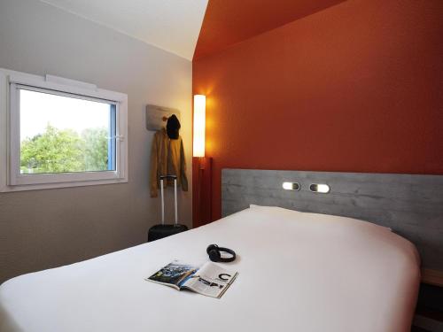 a bedroom with a white bed and a window at Ibis Budget - Lille Villeneuve D'Ascq in Villeneuve d'Ascq