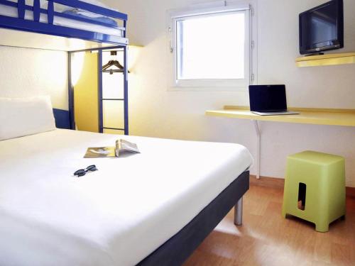 a hotel room with a bed and a tv at Ibis Budget - Lille Villeneuve D'Ascq in Villeneuve d'Ascq