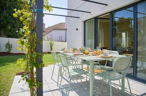 Una mesa y sillas en un patio. en Luxury Villa by the Sea w Salty Pool, by TimeCooler, en Oeiras