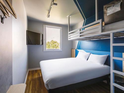 a bed in a room with a bunk bed at ibis budget Lyon Villeurbanne in Villeurbanne