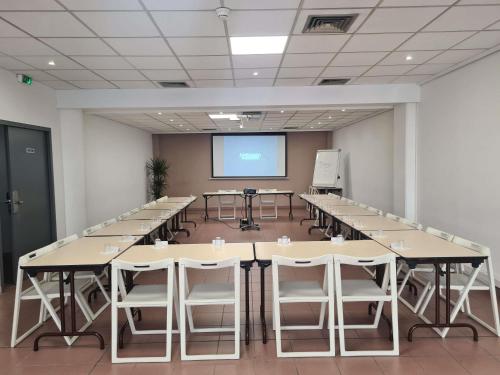 a conference room with tables and a projection screen at Ibis Budget Toulon Centre in Toulon