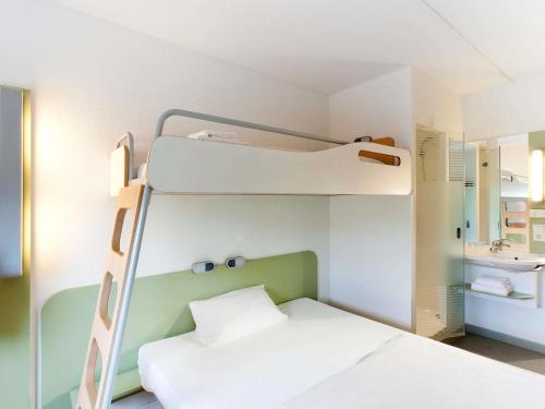 a bedroom with a bunk bed and a bathroom at Ibis Budget Toulon Centre in Toulon
