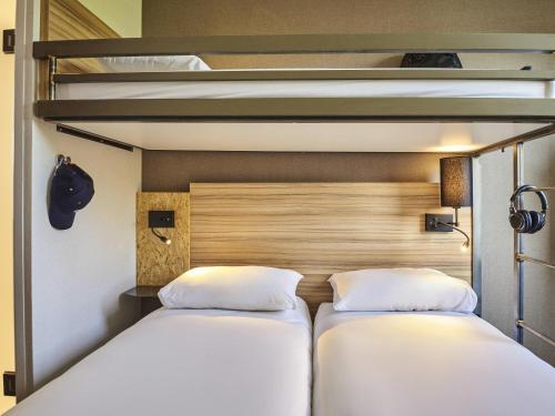 two beds in a room with two bunk beds at Greet Hotel Paris porte de la Chapelle - Aréna in Paris