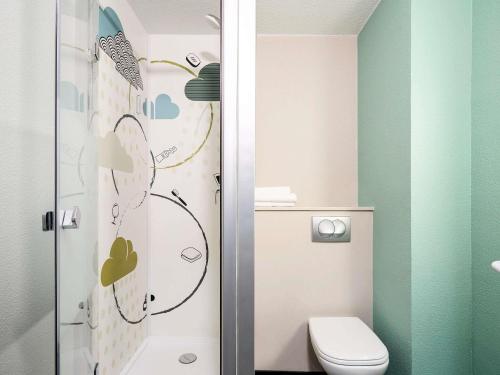 une petite salle de bain avec toilettes et douche dans l'établissement Ibis Budget Lille Gares Vieux-Lille, à Lille