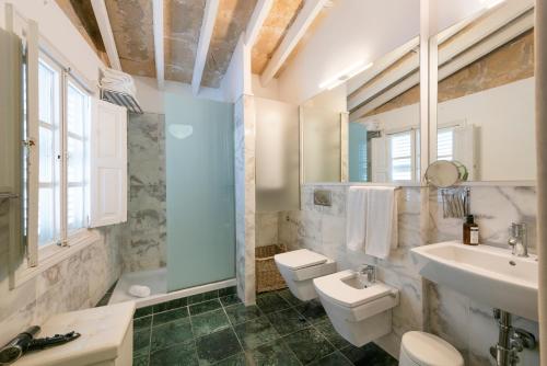 a white bathroom with two toilets and a sink at Brondo Architect Hotel in Palma de Mallorca
