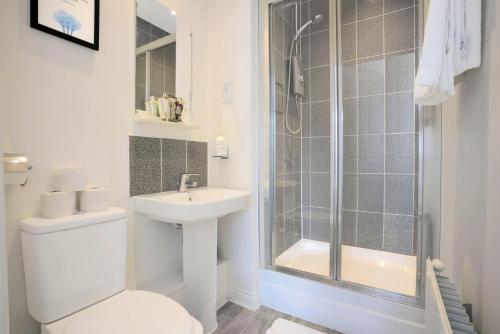 a bathroom with a shower and a toilet and a sink at 4 Bedroom 3 Bathroom House - Sleeps up to 8 - City Centre - Free Parking, Fast Wifi, Private Garden and Smart TV by Yoko Property in Milton Keynes