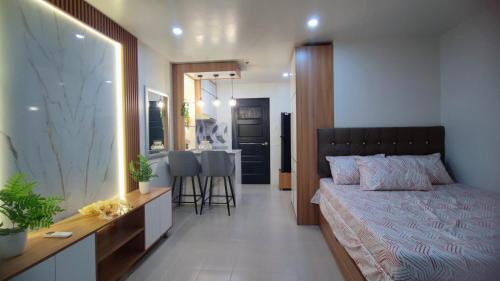 a bedroom with a bed and a dining room at Plumera Mactan near Airport in Bankal