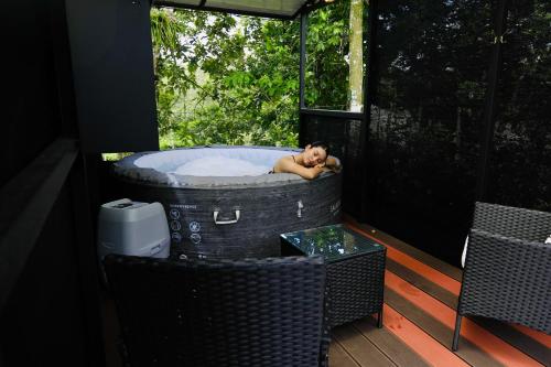 a man laying in a bath tub on a porch at Hotel Contenedores Corporativos in Platanal