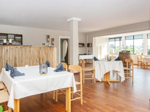 a dining room with white tables and chairs at Apartment in Holiday park- free waterpark in Ulfborg