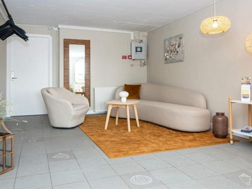 a living room with a couch and a table and a chair at Apartment in Holiday park- free waterpark in Ulfborg