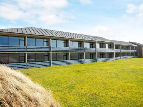a building with a grass field in front of it at Apartment in Holiday park- free waterpark in Ulfborg