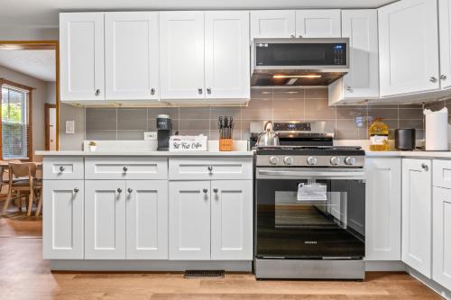 a kitchen with white cabinets and a black oven at Main Floor Tremont Home with KING Bed, Mins From DT, Pet Friendly in Cleveland