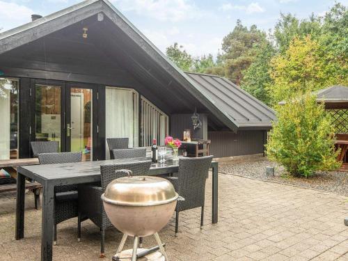 a patio with a grill and a table and chairs at 6 person holiday home in Fårvang in Fårvang