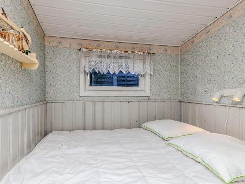 布洛克胡斯4 person holiday home in Blokhus-By Traum的有窗户的房间里的一张床