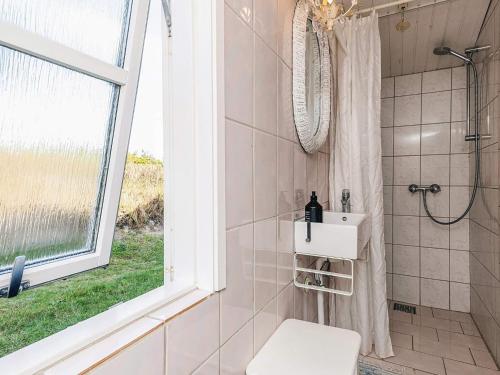 布洛克胡斯4 person holiday home in Blokhus-By Traum的带淋浴和卫生间的浴室以及窗户。
