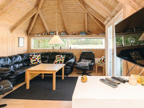 a living room with a leather couch and a table at 8 person holiday home in Fjerritslev-By Traum in Fjerritslev