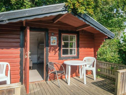 a small cabin with a table and chairs on a deck at Aabenraa Camping in Aabenraa