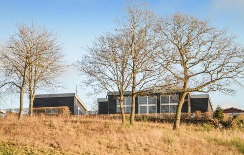 un edificio en un campo con árboles en primer plano en Lovely Home In Løgstrup With House Sea View, en Hjarbæk