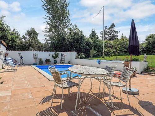 a patio with a table and chairs and a pool at 5 person holiday home in Frederiksværk-By Traum in Frederiksværk