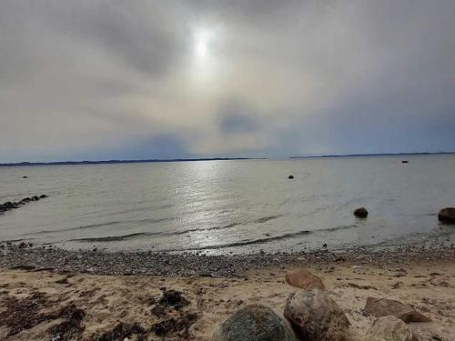 a beach with a cloudy sky and the water at 5 person holiday home in Frederiksværk-By Traum in Frederiksværk