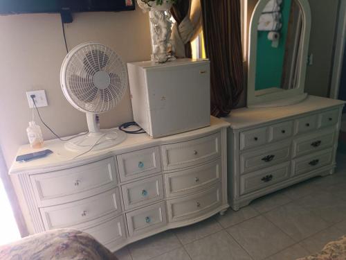 a white dresser with a fan and a mirror at Hospedaje Barato Mi Casita de Colores in Tijuana