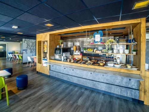 a restaurant with a counter with food on it at ibis budget La Roche Sur Yon Vendespace in Mouilleron-le-Captif