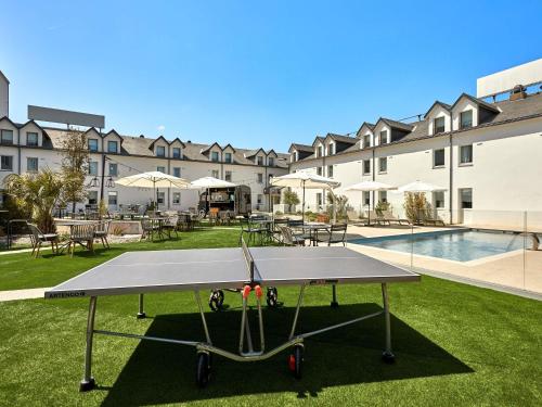 a ping pong table in front of a building at ibis budget La Roche Sur Yon Vendespace in Mouilleron-le-Captif