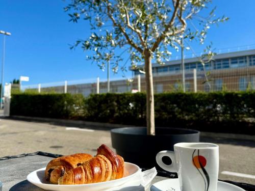 a plate of pastry on a table with a cup of coffee at Ibis Budget Marseille Vitrolles in Vitrolles
