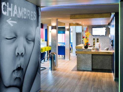 an office with a picture of a face on a wall at ibis budget Granville in Granville