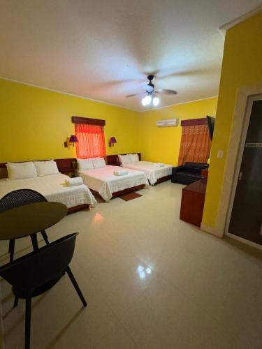 Cette grande chambre comprend 2 lits et une télévision. dans l'établissement China Town Hotel, à Caye Caulker