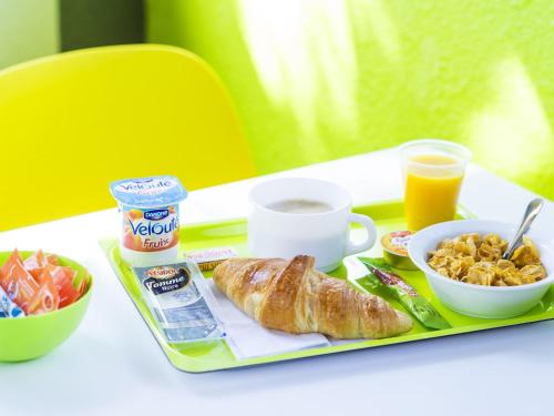 a tray with a breakfast of croissants and a cup of coffee at ibis Budget Pouilly-en-Auxois in Pouilly-en-Auxois