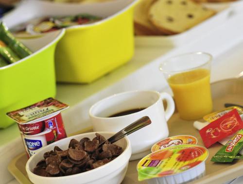 a tray with a cup of coffee and a bowl of chocolate chips at ibis Budget Pouilly-en-Auxois in Pouilly-en-Auxois
