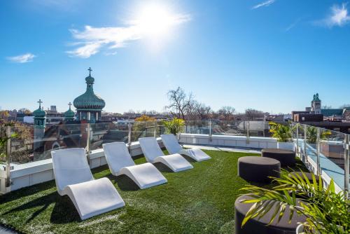 a group of white chairs sitting on top of a roof at CLUBHAUS Hotel in Montréal