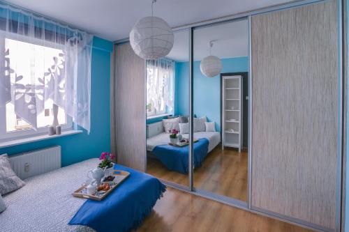 プツクにあるApartament Nadmorski Lazurowyの青い部屋(ベッド1台、鏡付)